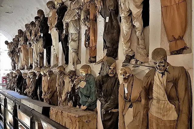 Galerie souterraine des catacombes des Capucins de Palerme, alignant les momies vêtues de leurs habits d'époque