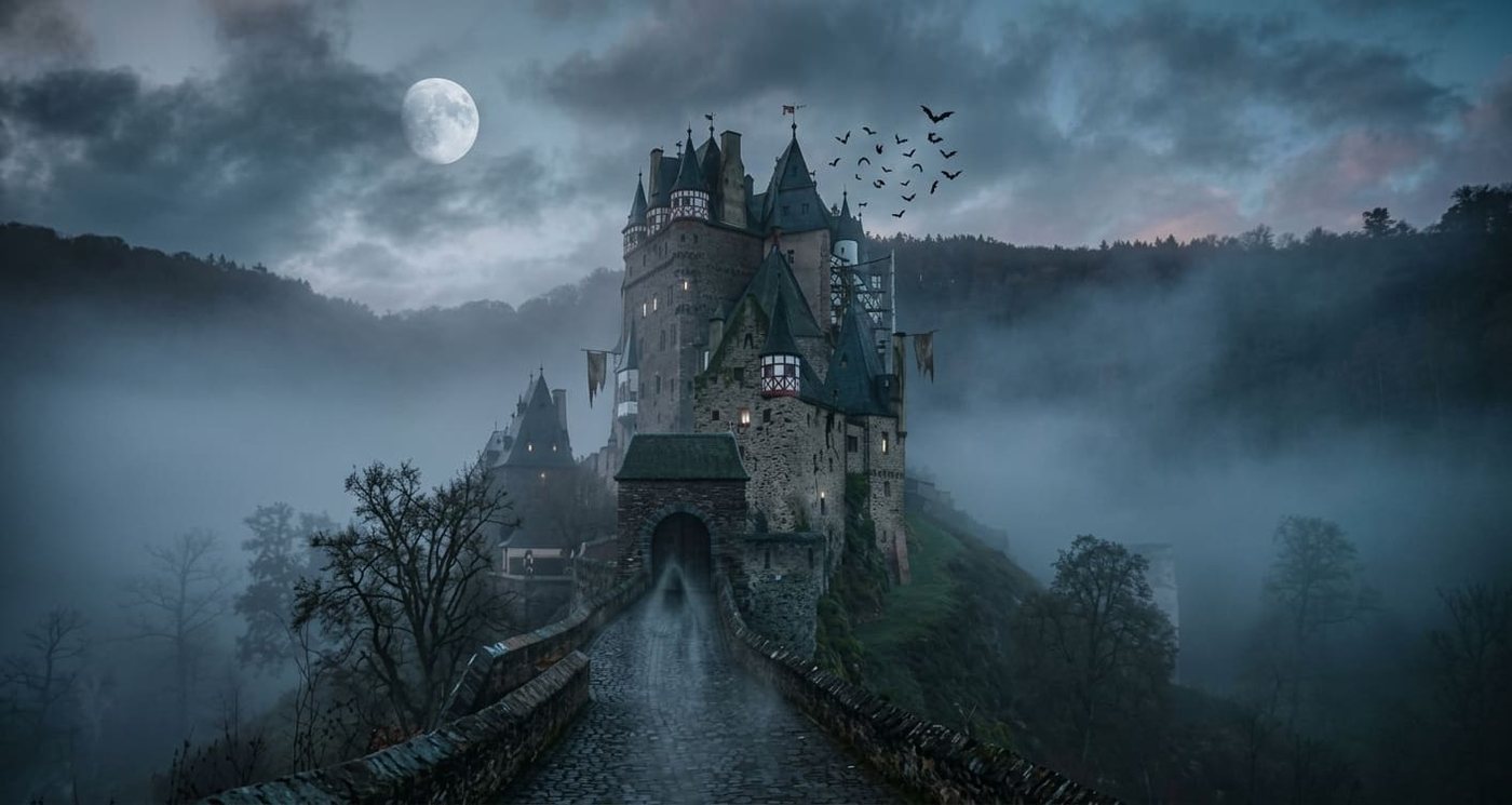 Silhouette d'un château gothique se découpant dans la brume au crépuscule, illustrant les châteaux hantés