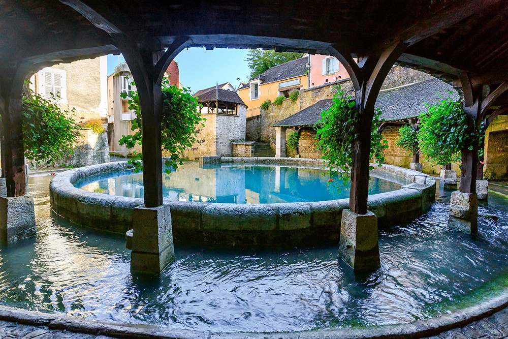 La Fosse Dionne, source vauclusienne aux eaux bleu-vert, entourée de son lavoir du XVIIIe siècle à Tonnerre