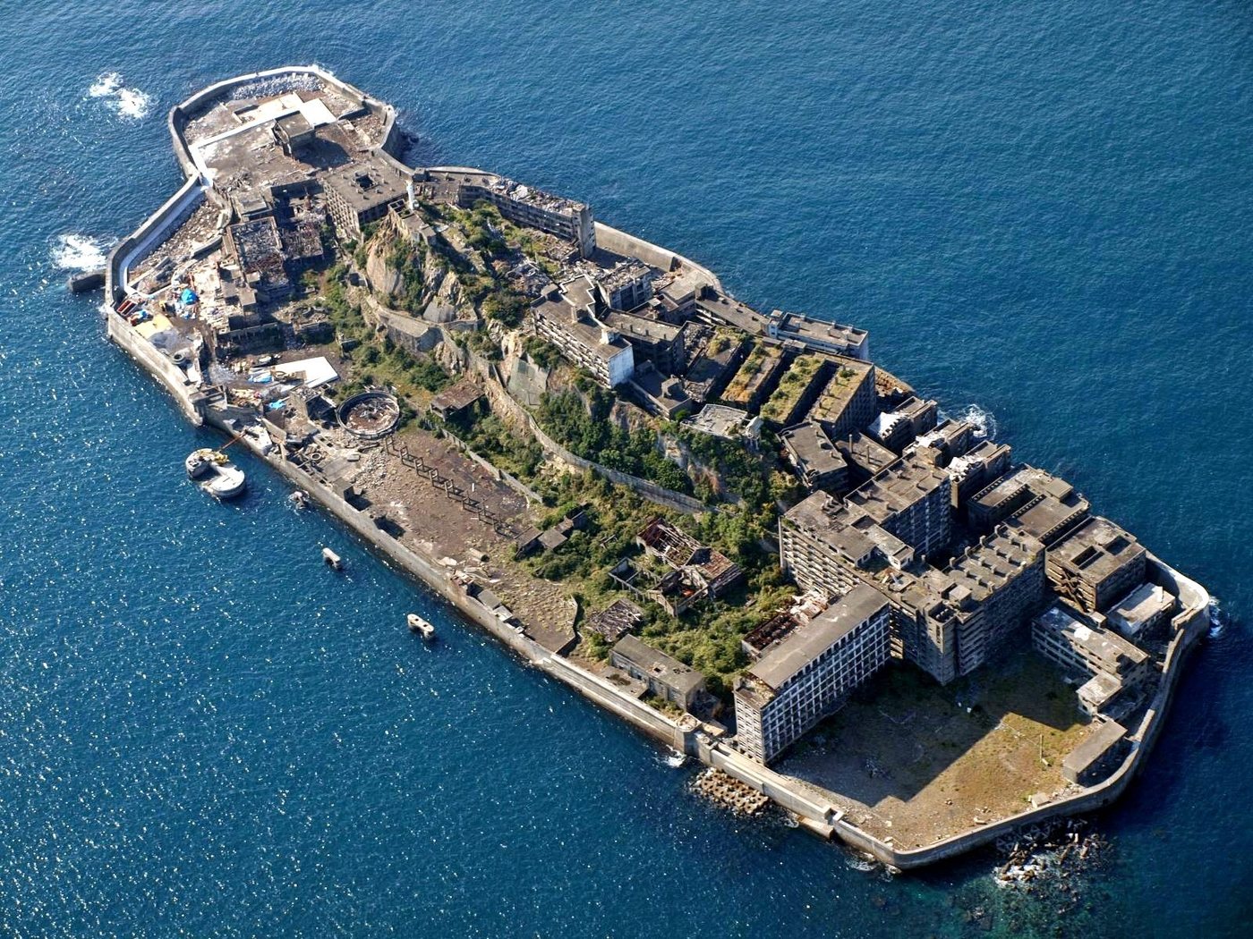 L'île de Hashima (Gunkanjima) au large de Nagasaki, hérissée de bâtiments de béton en ruine, vue depuis la mer