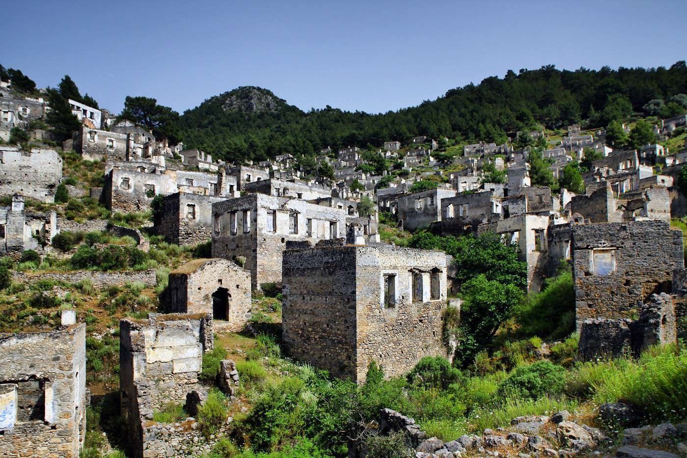 Les centaines de maisons de pierre sans toit du village fantôme de Kayaköy, accrochées à flanc de colline en Turquie